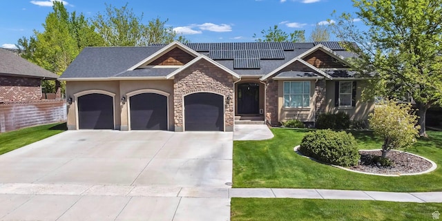 view of front of house featuring stone siding, a garage, concrete driveway, a front lawn, and roof mounted solar panels