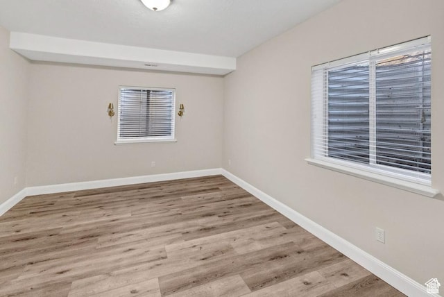 spare room featuring wood finished floors and baseboards