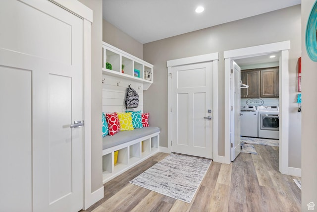 mudroom with recessed lighting, light wood-style flooring, baseboards, and washing machine and clothes dryer