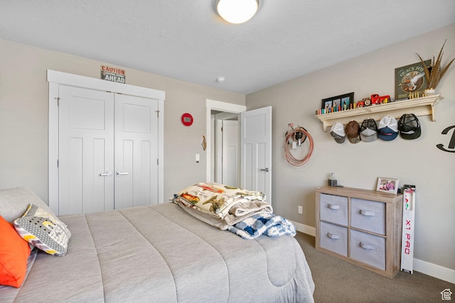 carpeted bedroom featuring a textured ceiling, a closet, and baseboards