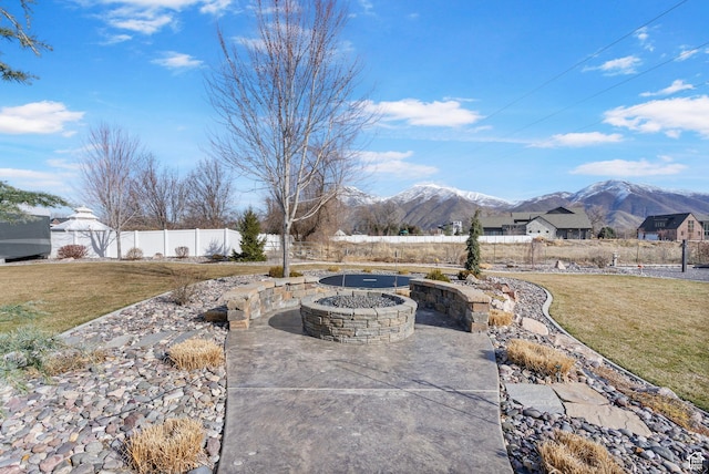exterior space featuring a mountain view, an outdoor fire pit, and fence