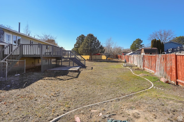 view of yard with a deck, stairs, and a fenced backyard