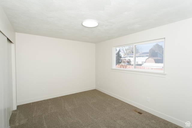 unfurnished bedroom with visible vents, baseboards, carpet flooring, a closet, and a textured ceiling