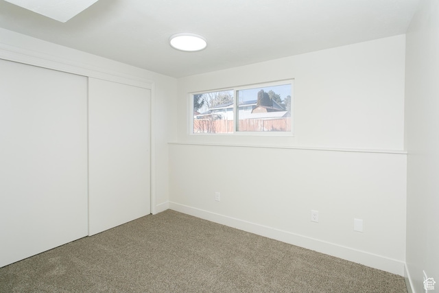 carpeted empty room with baseboards