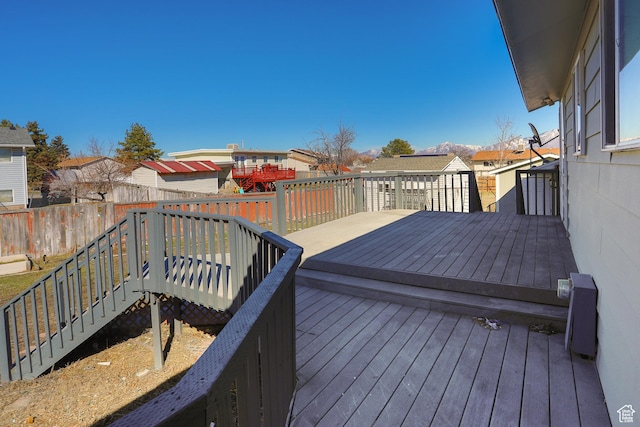 wooden deck featuring an outbuilding, a residential view, and fence