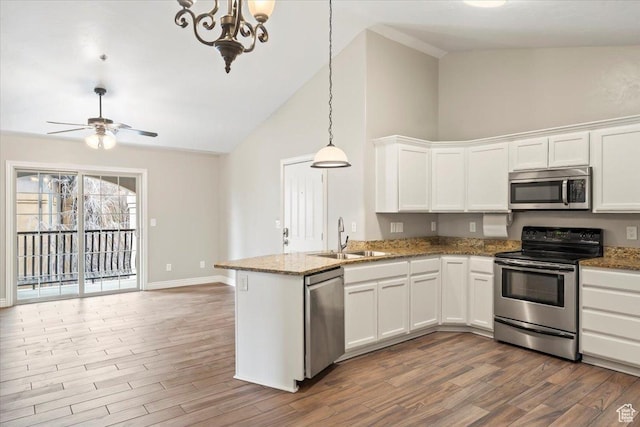684 S 2150 W Unit 303, Pleasant Grove, UT 84062 - kitchen featuring wood finished floors, a peninsula, a sink, stainless steel appliances, and white cabinetry