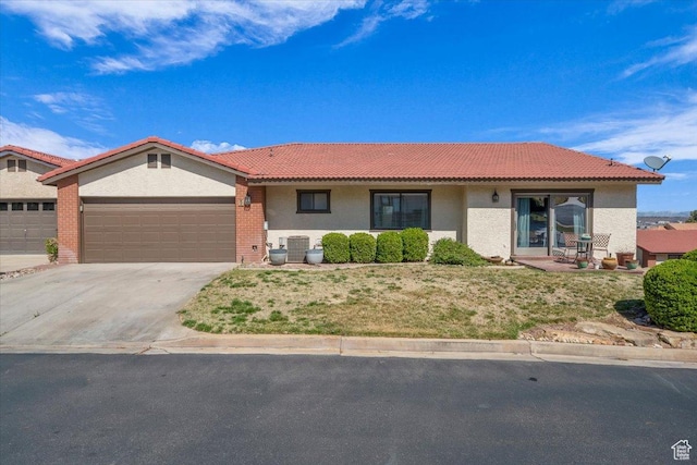 ranch-style house featuring cooling unit, an attached garage, stucco siding, concrete driveway, and a tiled roof