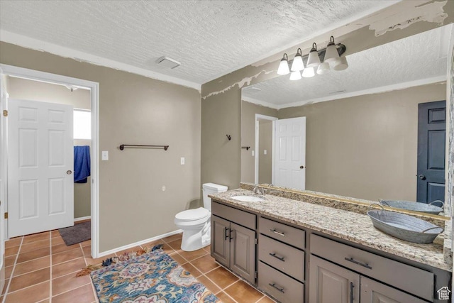 full bathroom featuring double vanity, a sink, a textured ceiling, tile patterned floors, and toilet