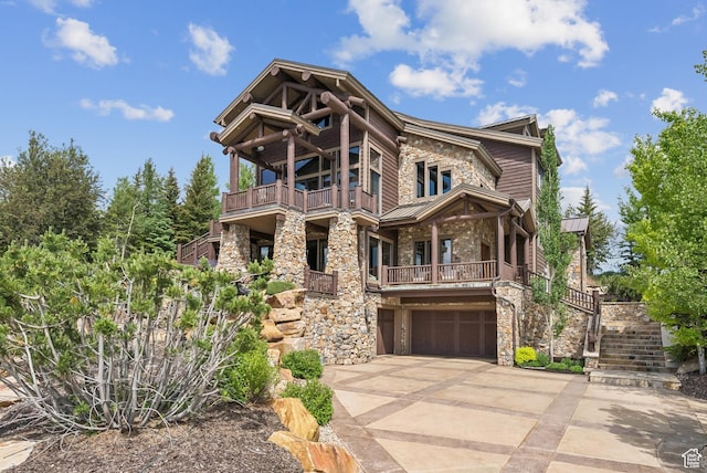 3438 Snow Top Ct, Park City, UT 84060 - view of front of house with stone siding, a standing seam roof, a balcony, a garage, and stairway