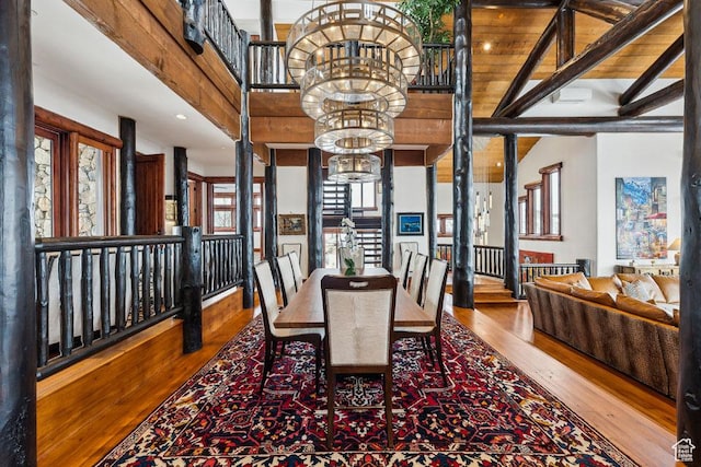 3438 Snow Top Ct, Park City, UT 84060 - dining area featuring a chandelier, beam ceiling, a towering ceiling, and wood finished floors