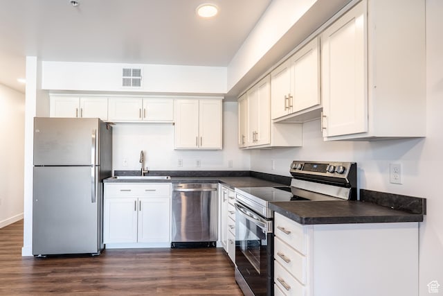 443 Kane Creek Blvd Unit 111, Moab, UT 84532 - kitchen featuring dark countertops, visible vents, stainless steel appliances, dark wood-style floors, and white cabinetry