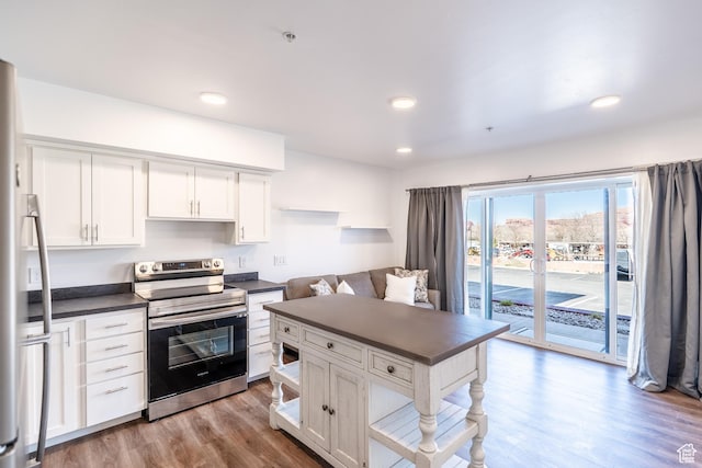 443 Kane Creek Blvd Unit 111, Moab, UT 84532 - kitchen featuring dark countertops, appliances with stainless steel finishes, wood finished floors, and white cabinetry