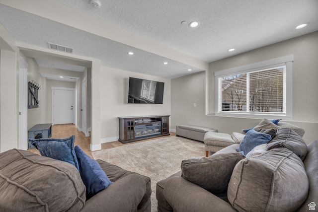 203 E Deer Run Loop Unit 40, Elk Ridge, UT 84651 - living room featuring recessed lighting, wood finished floors, a textured ceiling, baseboards, and a glass covered fireplace