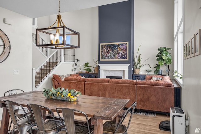 203 E Deer Run Loop Unit 40, Elk Ridge, UT 84651 - dining space featuring stairway, a chandelier, light wood finished floors, a fireplace, and a towering ceiling