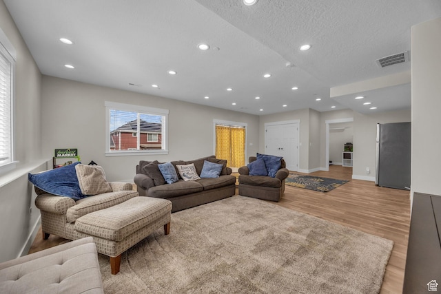 203 E Deer Run Loop Unit 40, Elk Ridge, UT 84651 - living area featuring light wood-type flooring, baseboards, recessed lighting, and a textured ceiling