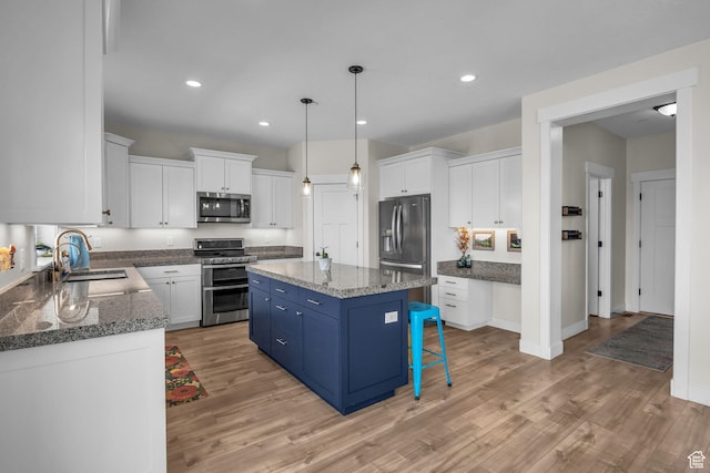 203 E Deer Run Loop Unit 40, Elk Ridge, UT 84651 - kitchen with appliances with stainless steel finishes, a sink, blue cabinets, a center island, and white cabinets