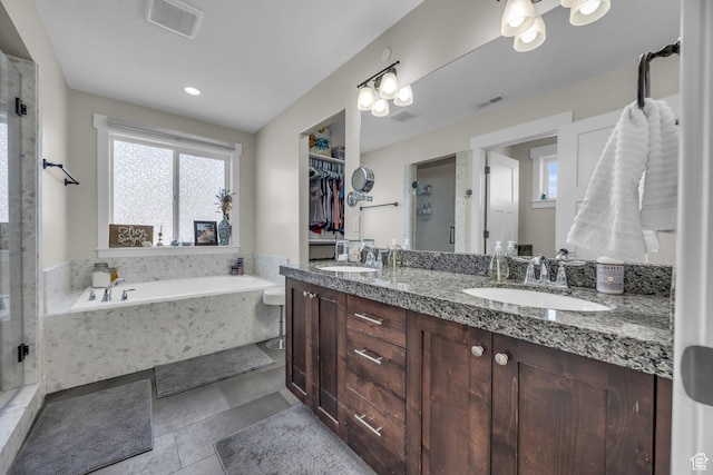 203 E Deer Run Loop Unit 40, Elk Ridge, UT 84651 - full bath featuring a stall shower, a garden tub, double vanity, a spacious closet, and tile patterned flooring