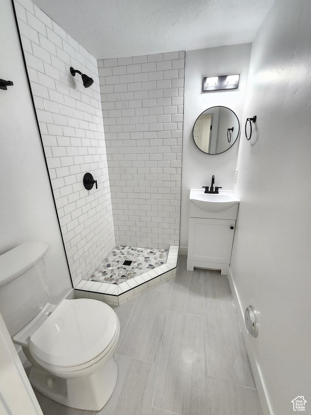 bathroom with baseboards, vanity, toilet, and a shower stall