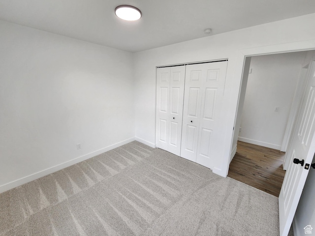 unfurnished bedroom with a closet, baseboards, and carpet floors