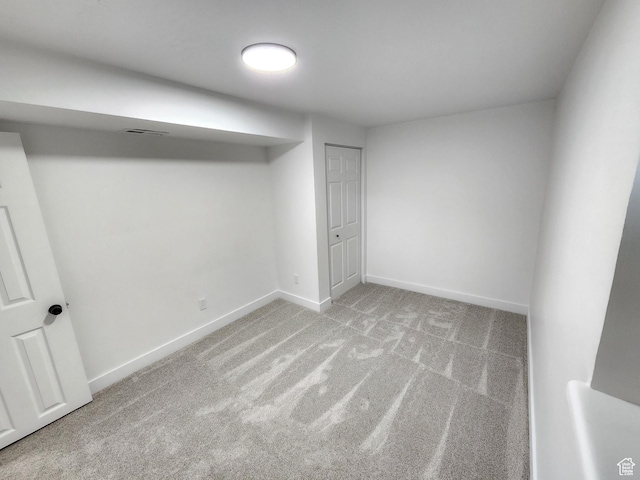 finished below grade area featuring visible vents, carpet floors, and baseboards