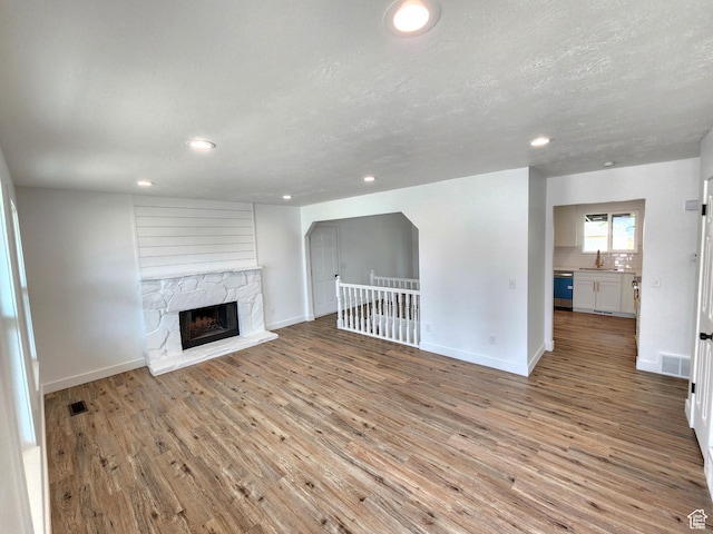 unfurnished living room with light wood-type flooring and baseboards