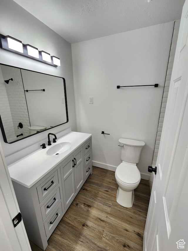 full bath with vanity, toilet, wood finished floors, and a shower