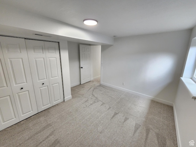 unfurnished bedroom with visible vents, carpet floors, baseboards, and a closet