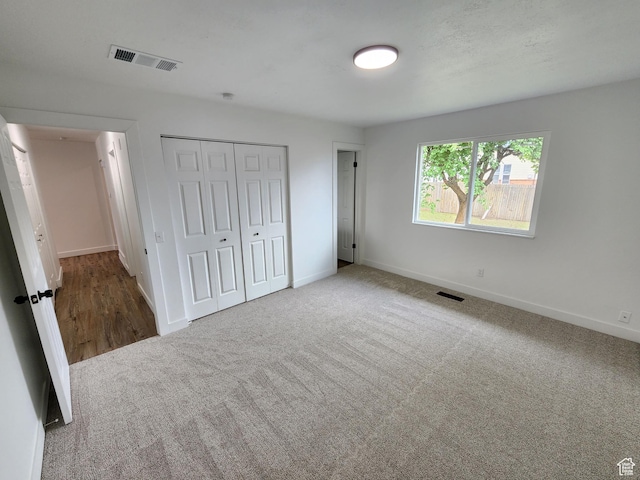 unfurnished bedroom featuring baseboards, visible vents, and carpet floors