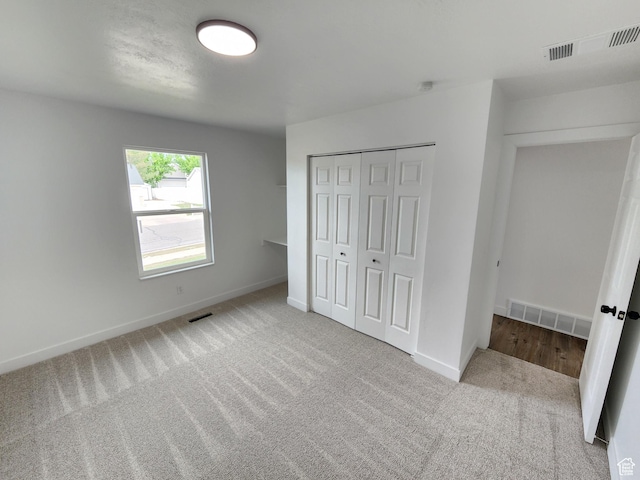 unfurnished bedroom featuring carpet, visible vents, and baseboards