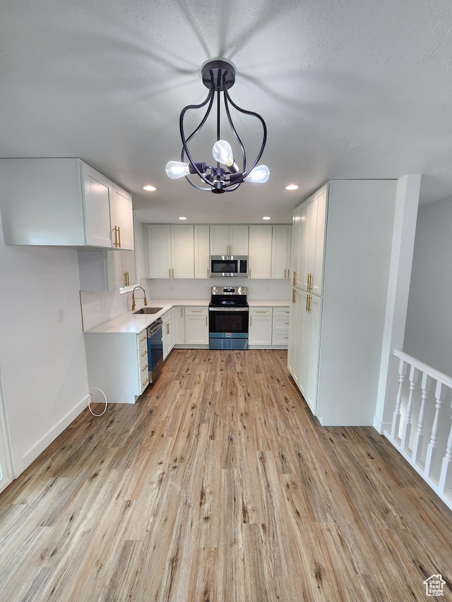 kitchen with stainless steel microwave, light wood-style flooring, dishwashing machine, and range with electric stovetop