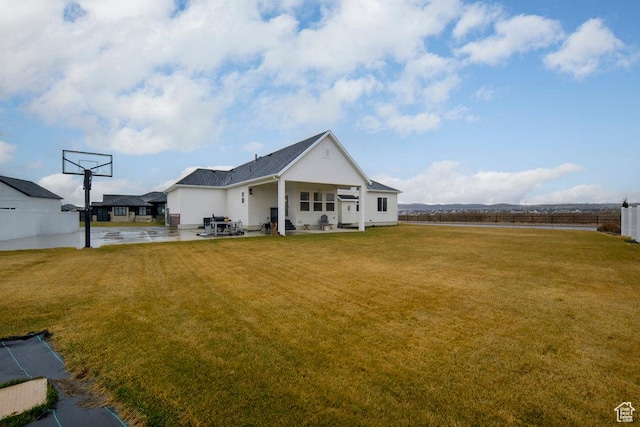 back of property featuring a patio area and a lawn