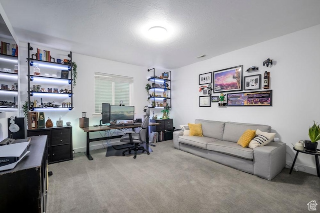 carpeted office with baseboards and a textured ceiling