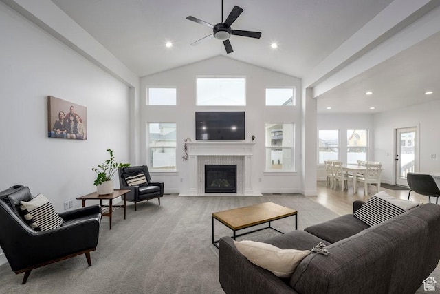 living room with a ceiling fan, baseboards, high vaulted ceiling, a fireplace with flush hearth, and recessed lighting