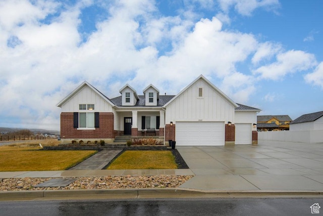 modern inspired farmhouse featuring board and batten siding, concrete driveway, an attached garage, a front yard, and brick siding
