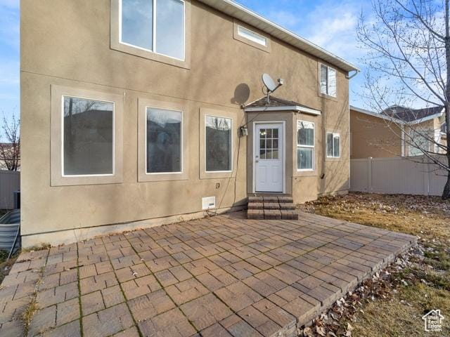 7009 W 7895 S, West Jordan, UT 84081 - back of property with stucco siding, a patio, fence, and entry steps