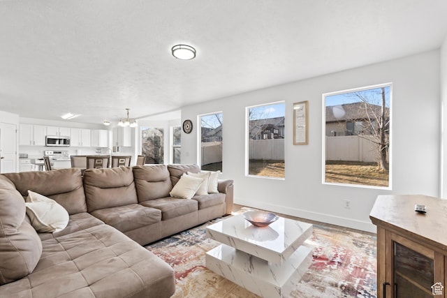7009 W 7895 S, West Jordan, UT 84081 - living room with a notable chandelier, light wood-style floors, and baseboards