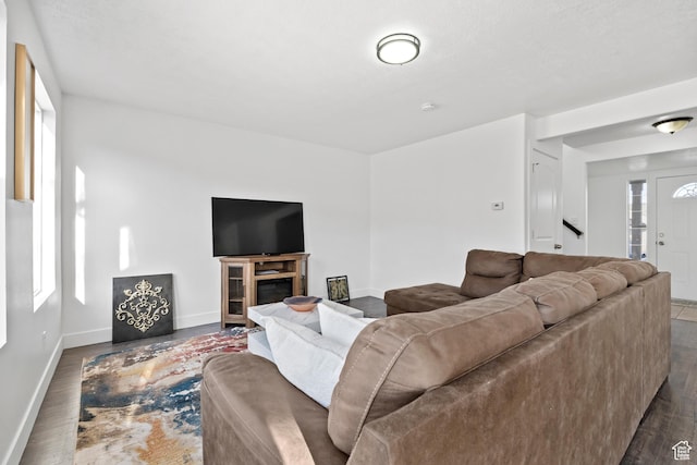 7009 W 7895 S, West Jordan, UT 84081 - living area featuring a glass covered fireplace, wood finished floors, and baseboards
