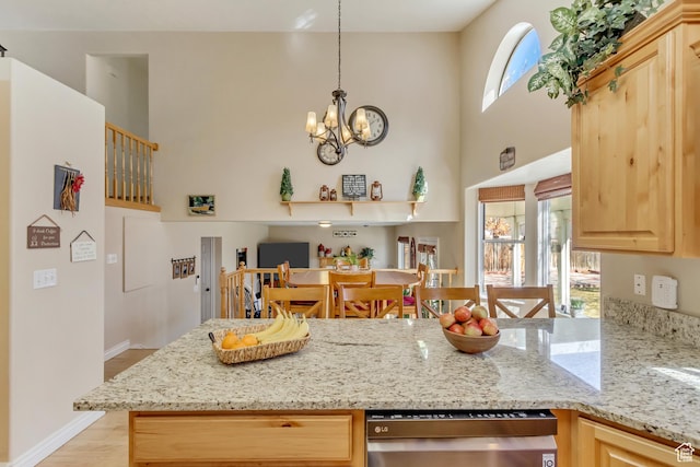 kitchen featuring a notable chandelier, light brown cabinetry, light stone counters, and light wood-style flooring