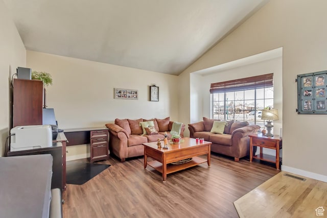 living area featuring baseboards, visible vents, light wood-style flooring, and lofted ceiling