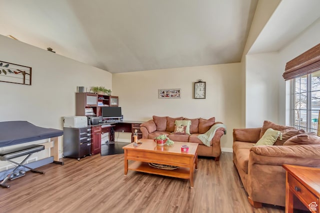 living area with light wood finished floors, baseboards, and lofted ceiling