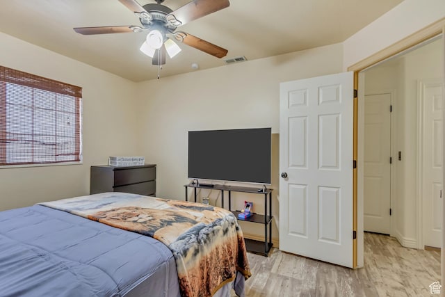 bedroom with light wood-type flooring, a ceiling fan, and visible vents