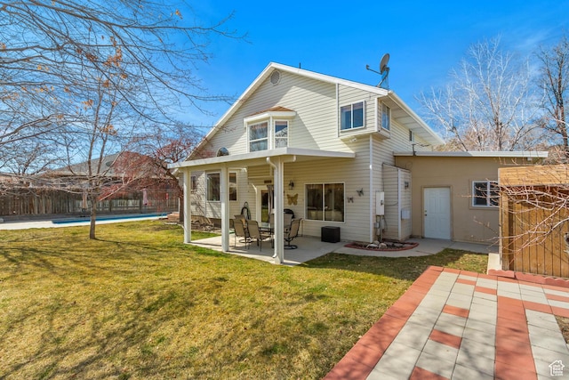 back of property featuring a yard, fence, a fenced in pool, and a patio area