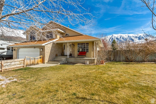 view of front of property featuring covered porch, fence, brick siding, and a front yard