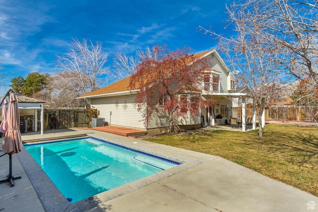 view of pool featuring a patio, a wooden deck, a fenced backyard, a yard, and a fenced in pool