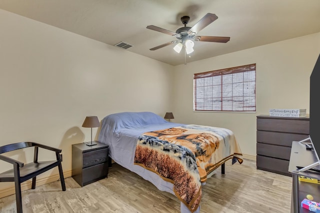bedroom with ceiling fan, light wood-style flooring, baseboards, and visible vents