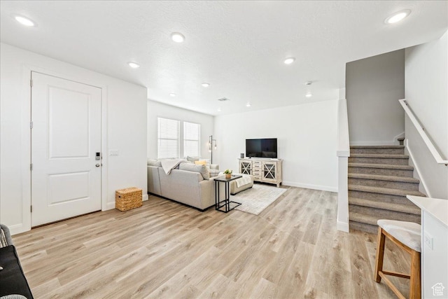 living area with stairs, recessed lighting, and light wood finished floors