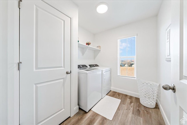 washroom featuring washer and dryer, light wood-type flooring, baseboards, and laundry area