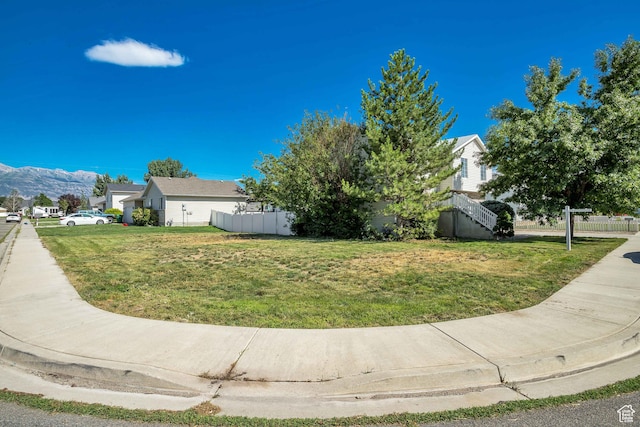 view of side of property featuring stairway, a yard, and fence