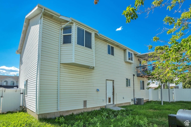 rear view of property with central AC and fence