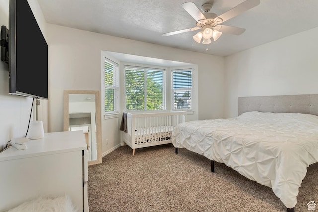 carpeted bedroom featuring baseboards and ceiling fan